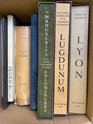 many books in a cardboard box on the shelf