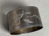 a close up of a silver cuff with flowers on it