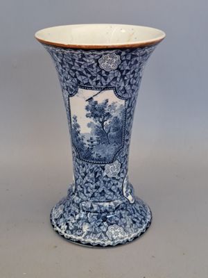 a blue and white vase with a picture of a tree on it