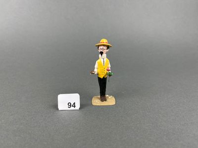 a close up of a figurine of a man with a hat and yellow vest