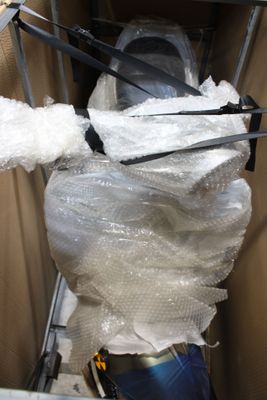 une photo de toilettes dans un carton recouvert de film plastique