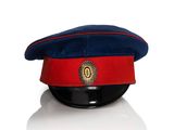 un bonnet rouge et bleu orné d'un écusson sur le dessus