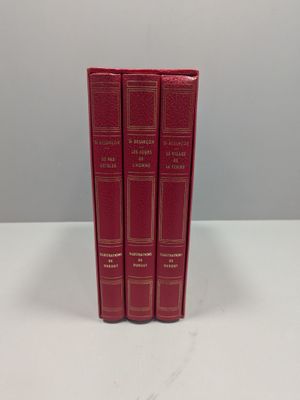 un lot de trois livres rouges posés sur une table blanche