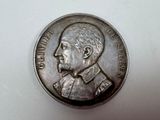 une pièce d'argent sur laquelle figure l'image d'un homme