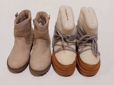trois paires de bottes d'hiver pour femmes alignées sur une surface blanche