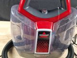 a red and black vacuum that is on a wooden table