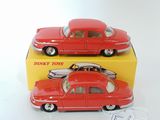 two red toy cars sitting next to each other on a white surface
