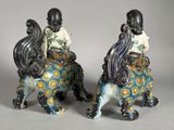 two figurines of two people riding on a horse