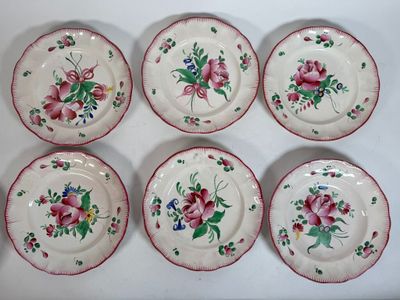 six plates with floral designs on them sitting on a white surface