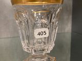 a glass vase with a gold rim sitting on a glass shelf