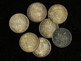 un ensemble de cinq pièces d'argent et d'or sur un fond noir