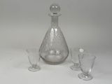 three glasses and a decanter sitting on a table