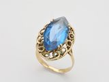 une bague en or sertie d'une topaze bleue au centre