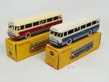 trois bus miniatures sont posés sur des cartons, sur une surface blanche