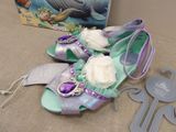 a pair of purple and green shoes and a book on a table