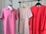 three women ' s dresses on a rack in a white room