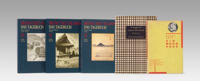 trois livres sont empilés sur une table