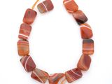 une photo d'un collier composé de perles d'agate rayées de rouge et de blanc