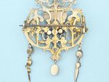 a gold brooch on a blue background