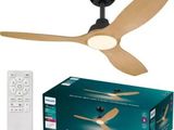 une photo d'un ventilateur de plafond muni d'une télécommande, devant une boîte