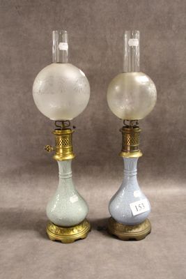 paire de lampes anciennes en verre sur des pieds en laiton, avec des globes en verre dépoli