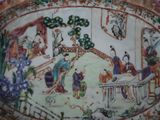 a plate with a painting on it with people in it