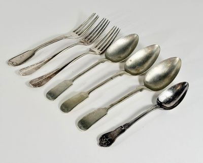six spoons and a fork on a white surface