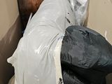 une poubelle pleine de déchets posée au milieu d'une pièce