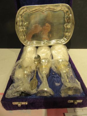 un étui en velours violet contenant de l'argenterie et le reflet d'une femme dans un miroir