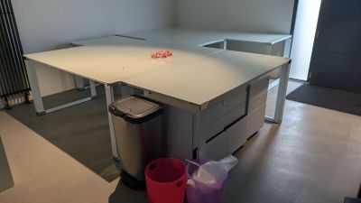 un bureau avec une poubelle et une poubelle dans un coin