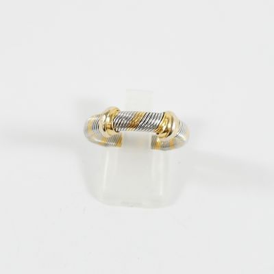 gros plan d'une bague en or et en argent sur une surface blanche