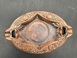 an old brass plate with a decorative design on it