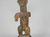 an old statue of a man standing on a wooden base