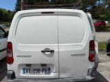a white van parked in a parking lot next to a tree