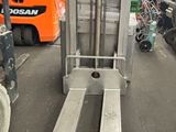 un chariot élévateur dans un entrepôt, avec d'autres véhicules en arrière-plan