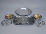 a group of silverware including a tray, spoons, and a plate