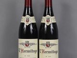 deux bouteilles de vin rouge posées sur une table en verre