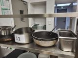 de nombreuses casseroles et poêles sur l'étagère de la cuisine