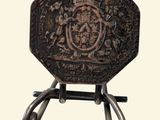 a small metal object with a coat of arms on it