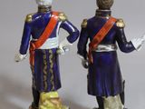 pair of figurines of two men dressed in military uniforms