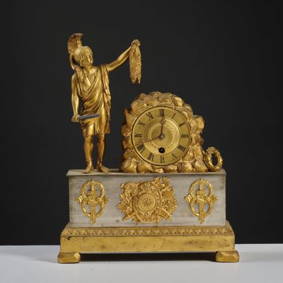 a gold statue of a man holding a bird and a clock