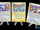 Trois cartes Pokémon différentes sont représentées sur un fond noir.