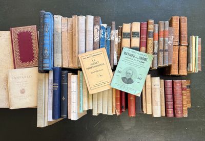 a lot of books that are stacked on a shelf