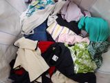 a pile of clothes in a basket on a bed