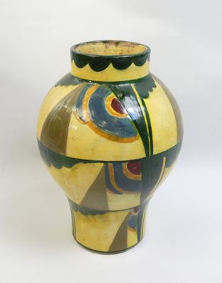 a yellow vase with a blue and green design on it