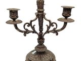 a metal candelab with three candles on it