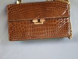 un sac à main en cuir de crocodile marron avec une chaîne dorée