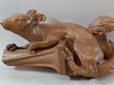a wooden sculpture of a dog laying on a bench