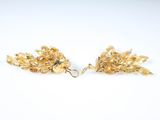 a pair of gold earrings on a white surface