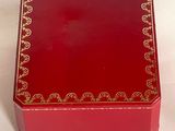 a red box with gold trim on it on a white surface